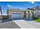 Well-maintained home features a two-car garage and stone detailing on the facade at 3086 Kestrel St, Brighton, CO 80601