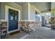 Inviting front door with stone accents and a wreath, welcoming visitors into the home at 3086 Kestrel St, Brighton, CO 80601
