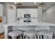 Modern kitchen featuring white cabinets, stainless steel appliances, quartz countertop, and stylish bar stool seating at 3086 Kestrel St, Brighton, CO 80601