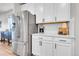 Kitchen detail featuring stainless steel refrigerator, white cabinets, and quartz countertops with modern decor at 3086 Kestrel St, Brighton, CO 80601