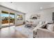 Bright living room featuring a large sofa, modern rug, and sliding glass doors leading to an outdoor deck at 3086 Kestrel St, Brighton, CO 80601
