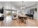 Cozy living room with natural light, stylish dining table, hardwood floors, and access to outdoor patio at 3086 Kestrel St, Brighton, CO 80601