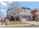 Two-story house with gray siding, a large driveway and landscaping at 4942 S Zephyr St, Littleton, CO 80123