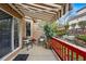 Covered back porch with awning, red fence, and outdoor seating for relaxing at 12610 E Wesley Pl, Aurora, CO 80014