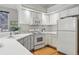 Well-lit kitchen with white appliances, ample cabinet space, and modern fixtures at 12610 E Wesley Pl, Aurora, CO 80014