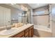 Bathroom with dual sinks, large mirror, and tub/shower combo at 14183 Madison Way, Thornton, CO 80602