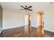 Large primary bedroom with hardwood floors, ceiling fan, and ensuite bathroom and closet entrances at 14183 Madison Way, Thornton, CO 80602