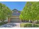 Charming two-story home featuring a two-car garage, red shutters, and mature trees in a well-maintained neighborhood at 14183 Madison Way, Thornton, CO 80602