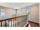 Upstairs landing area featuring hardwood floors, staircase, and ample natural lighting at 14183 Madison Way, Thornton, CO 80602