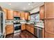 Well-equipped kitchen featuring stainless steel appliances, wooden cabinets, and stylish backsplash at 14183 Madison Way, Thornton, CO 80602