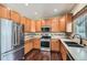 Modern kitchen with stainless steel appliances, ample wood cabinets, and stylish backsplash at 14183 Madison Way, Thornton, CO 80602