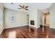 Spacious living room featuring hardwood floors, a cozy fireplace, built-in shelving, and a ceiling fan at 14183 Madison Way, Thornton, CO 80602
