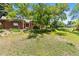 Spacious, shady backyard showcasing a brick ranch-style home with a lush lawn and outdoor play area at 1475 Kingsbury Ct, Golden, CO 80401