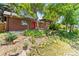 Brick ranch-style home with a walkout patio, shade trees, and a landscaped backyard with rocky garden at 1475 Kingsbury Ct, Golden, CO 80401