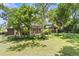 Expansive backyard featuring mature trees, a brick home, and a patio area with a pergola at 1475 Kingsbury Ct, Golden, CO 80401