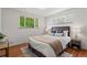 Comfortable bedroom featuring a large window overlooking green trees, providing ample natural light at 1475 Kingsbury Ct, Golden, CO 80401