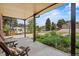 Cozy covered patio overlooking a front yard with lush landscaping and a view of the neighborhood at 1475 Kingsbury Ct, Golden, CO 80401