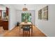Bright dining room with hardwood floors, stylish light fixture, and large windows offering backyard views at 1475 Kingsbury Ct, Golden, CO 80401