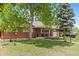 Brick home featuring mature trees, a well-kept lawn, and a welcoming front porch at 1475 Kingsbury Ct, Golden, CO 80401