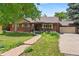 Charming brick home featuring a well-maintained front yard, landscaping, and an attached two-car garage at 1475 Kingsbury Ct, Golden, CO 80401