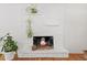 Cozy fireplace with white painted brick, decorative plants, and a rustic mantel at 1475 Kingsbury Ct, Golden, CO 80401