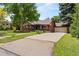 Charming brick ranch-style home with a well-manicured front lawn, large driveway, and attached garage at 1475 Kingsbury Ct, Golden, CO 80401