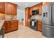 Kitchen with wooden cabinetry, granite countertops, stainless steel appliances, and tile flooring at 1475 Kingsbury Ct, Golden, CO 80401