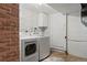 Laundry room featuring washer, dryer, brick accent wall, and utility sink at 1475 Kingsbury Ct, Golden, CO 80401