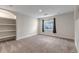 Finished basement area featuring neutral carpet, built-in shelving, and a window at 19551 E Mann Creek Dr # B, Parker, CO 80134