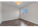 Bright bedroom features wood floors, a contemporary light fixture, a large window and neutral paint at 19551 E Mann Creek Dr # B, Parker, CO 80134