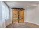 Cozy bedroom showcasing rustic sliding barn doors and soft natural light from the adjacent window at 19551 E Mann Creek Dr # B, Parker, CO 80134