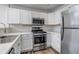 Bright kitchen featuring stainless steel appliances, including a range, microwave, and fridge at 19551 E Mann Creek Dr # B, Parker, CO 80134