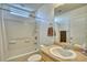 Bathroom features a vanity, toilet, tub and shower with white tile surround at 5295 Andes St, Denver, CO 80249