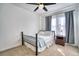 Cozy bedroom features a bed, a bedside table with a lamp, a ceiling fan, and windows with curtains at 5295 Andes St, Denver, CO 80249