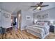 Cozy bedroom with wood-look flooring, ceiling fan, white bedding, and neutral gray walls at 5295 Andes St, Denver, CO 80249
