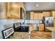 Bright kitchen showcases stainless steel appliances, granite countertops, white backsplash and light maple cabinets at 5295 Andes St, Denver, CO 80249