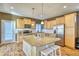 Open kitchen with granite island, stainless steel appliances, hardwood floors, and an adjacent dining area at 5295 Andes St, Denver, CO 80249