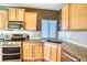 Bright kitchen features stainless steel appliances, granite countertops, white subway tile backsplash and wood cabinets at 5295 Andes St, Denver, CO 80249