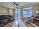 Bright living room featuring wood floors, a ceiling fan, large windows, and a sliding glass door at 5295 Andes St, Denver, CO 80249