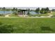 Scenic view of a park with a lake, green grass, and a decorative gazebo at 5295 Andes St, Denver, CO 80249