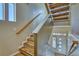 Staircase with wooden handrail, wood-look steps, and a view of the front door at 5295 Andes St, Denver, CO 80249
