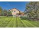 Scenic backyard with manicured lawn, white fence, and a pergola-covered patio for outdoor enjoyment at 1378 S Duquesne Ct, Aurora, CO 80018