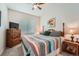 This bedroom features natural light, a ceiling fan, comfortable furniture, and soft carpeting at 1378 S Duquesne Ct, Aurora, CO 80018