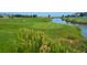 Picturesque view of the golf course with lush green grass, a small lake, and colorful flowers in the foreground at 1378 S Duquesne Ct, Aurora, CO 80018