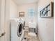 Well-equipped laundry room with modern washer/dryer, utility sink, and ample storage space at 1378 S Duquesne Ct, Aurora, CO 80018