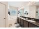 This main bathroom offers double sinks, granite counters, a soaking tub and natural light at 1378 S Duquesne Ct, Aurora, CO 80018