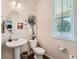 This powder room features a pedestal sink, decorative art, and a window for natural light at 1378 S Duquesne Ct, Aurora, CO 80018