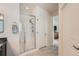 This shower has a clear glass enclosure and bench in a naturally lit main bathroom at 1378 S Duquesne Ct, Aurora, CO 80018