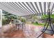 Covered patio featuring an outdoor dining set and a relaxing swing, complemented by mature trees and tasteful landscaping at 5146 S Argonne St, Centennial, CO 80015