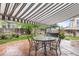 Covered patio featuring an outdoor dining set and a relaxing swing, complemented by mature trees and a rock water feature at 5146 S Argonne St, Centennial, CO 80015